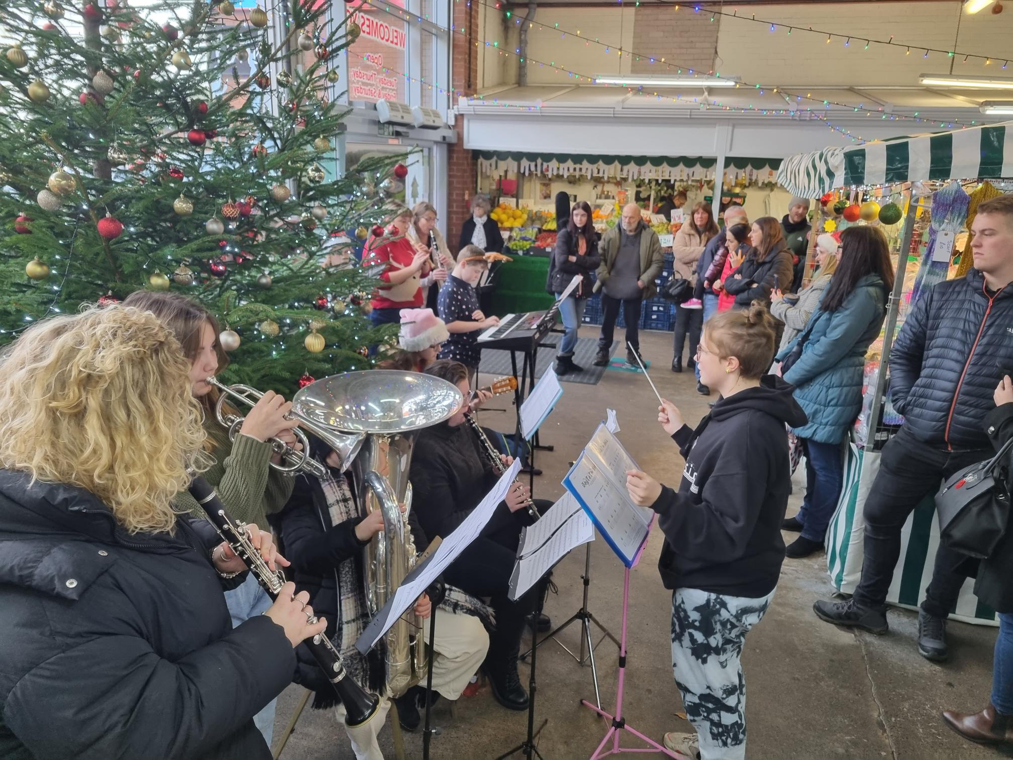 The David Nieper Academy band performing in the community at Alfreton Indoor Market